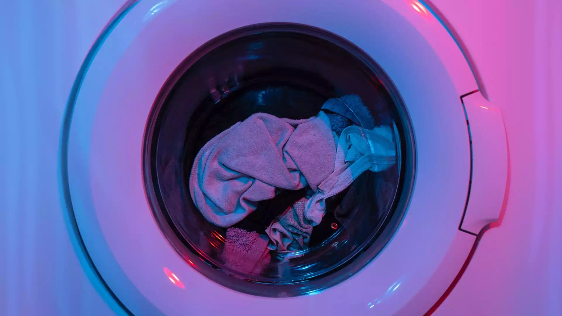 laundry in washing machine with colorful lighting