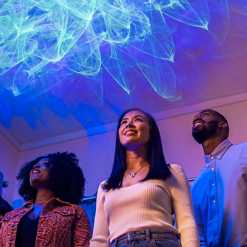 people smiling at ark aurora effect shining on ceiling