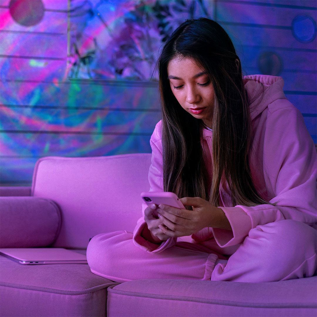 woman sitting on pink couch with velarus aurora light