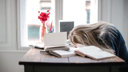 woman with her face on a desk