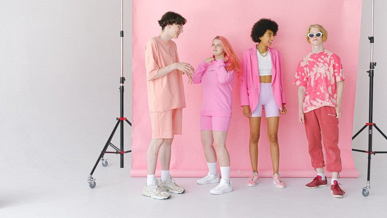 four teens in front of pink photo backdrop