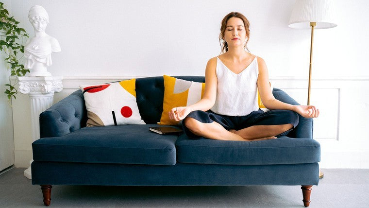woman meditating on couch