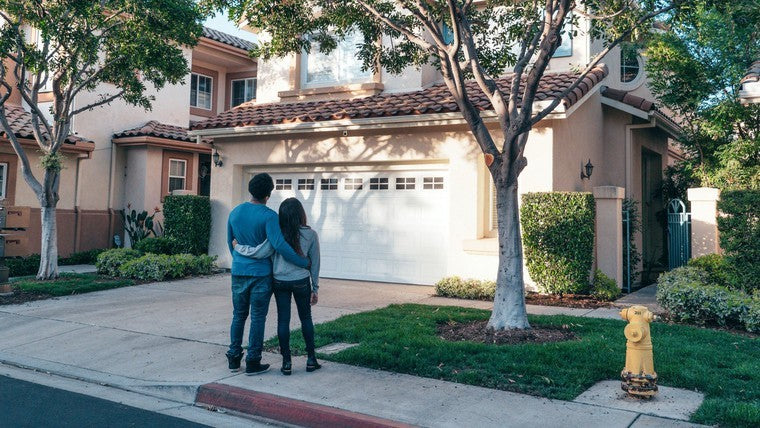 couple standing together outside of house