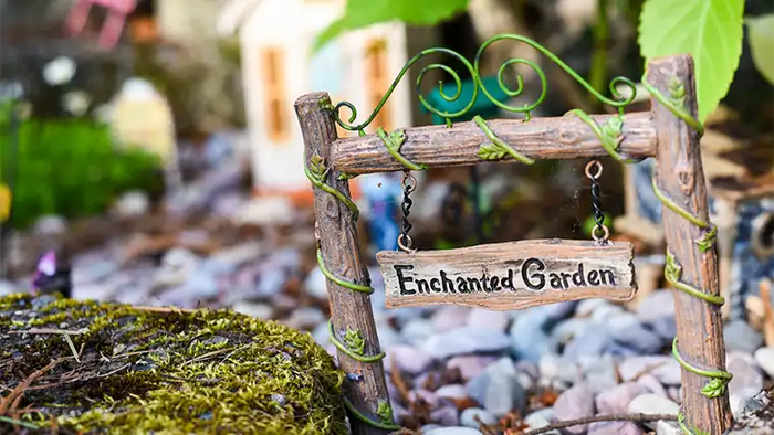 fairy garden with moss and miniature garden sign