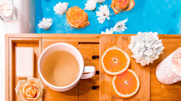self care bath tray with orange slices and flowers