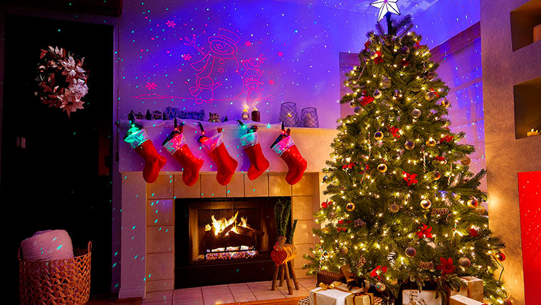 lighted christmas tree near fireplace with stockings and laser lights