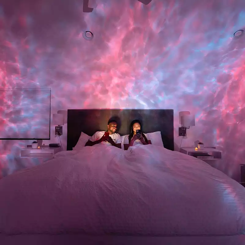 couple in bedroom with pink and cyan galaxy lights