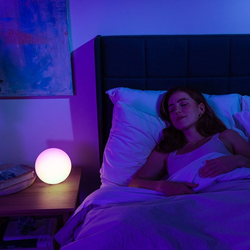woman sleeping next to blissradia desk lamp